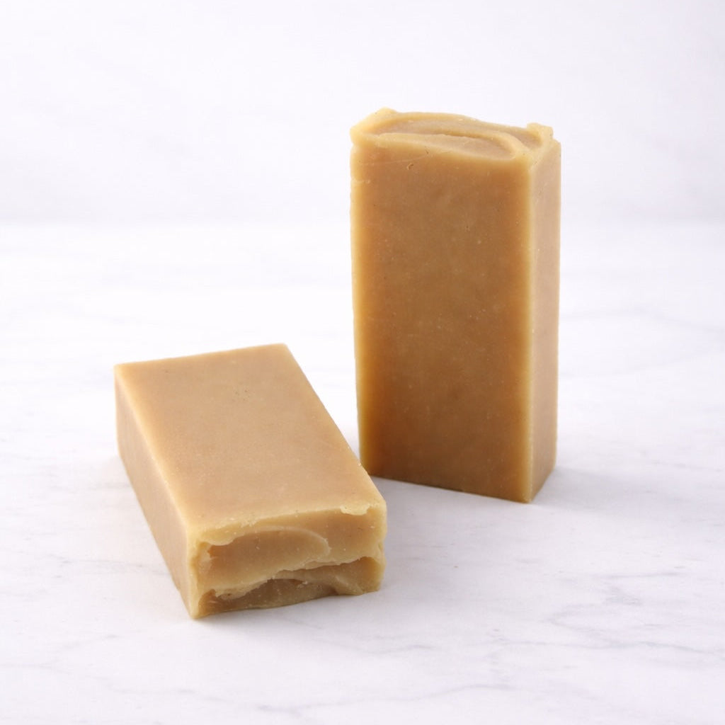 Two rectangular bars of brown soap on a white background