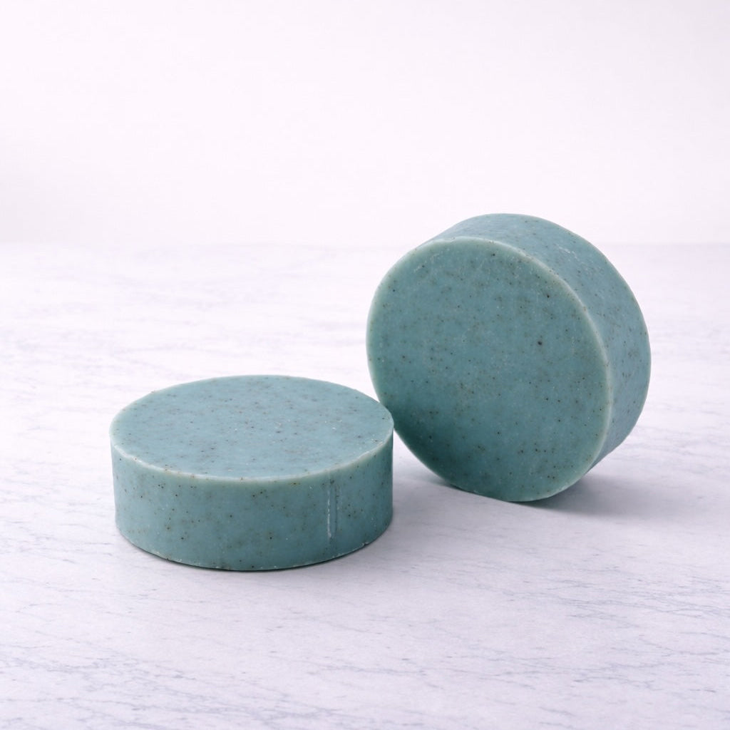 Two round bars of blue soap with ground walnut shell