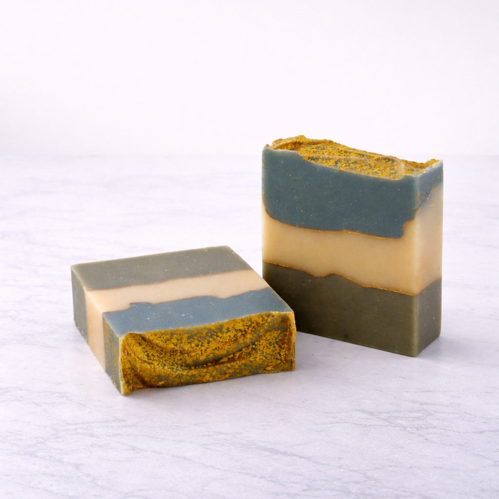 Three layered soap bars on a textured white surface