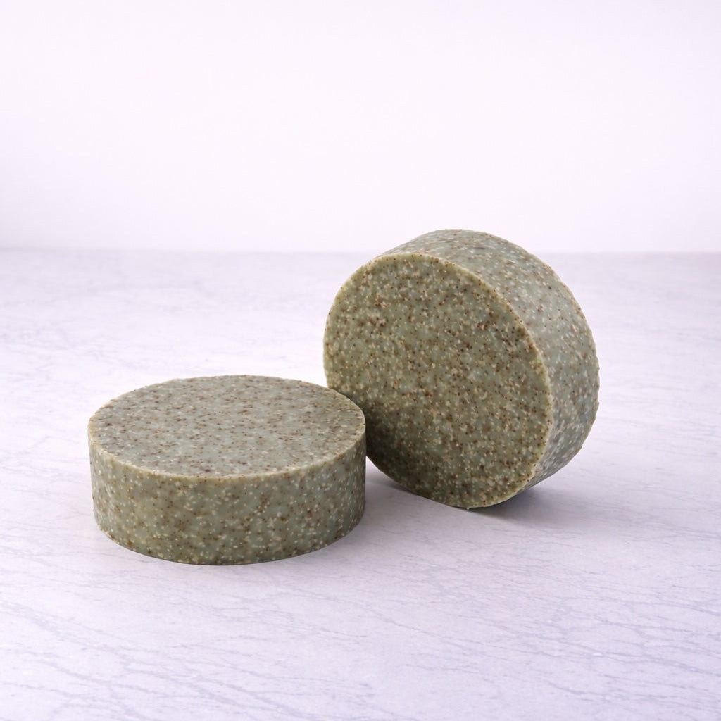 Two round bars of eucalyptus soap with ground walnut shell