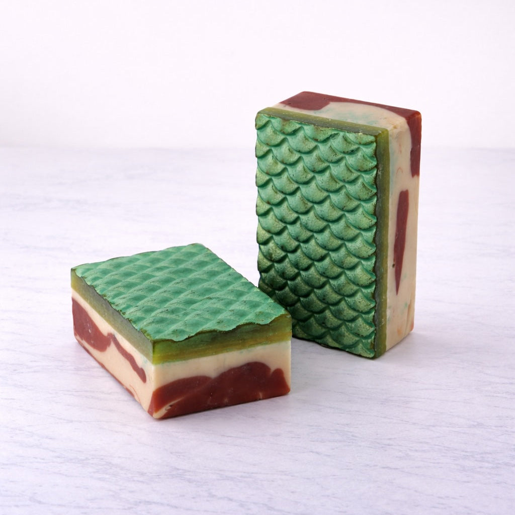 Two mermaid-scale patterned soap bars on a white background