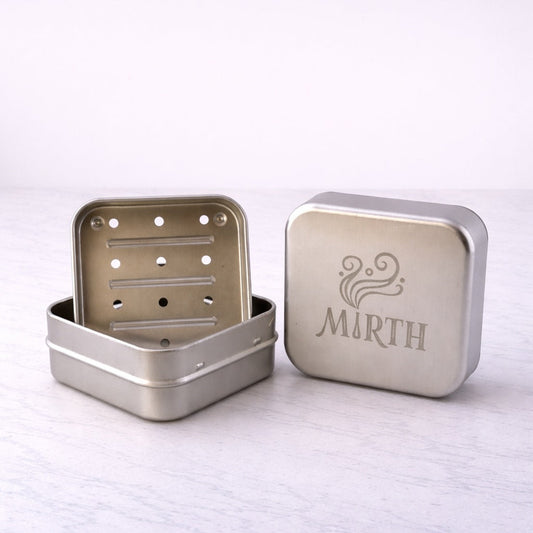 Travel tin for soap with metal drainage container.